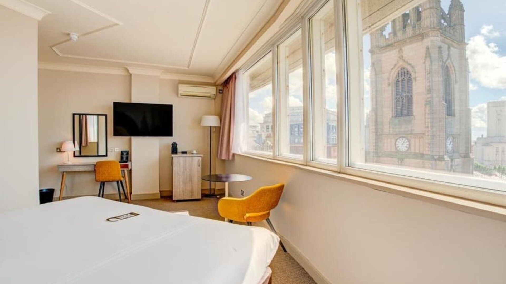 Guest room with large windows offering city views, workspace, and seating area at Atlantic Tower Hotel Liverpool By Sunday.