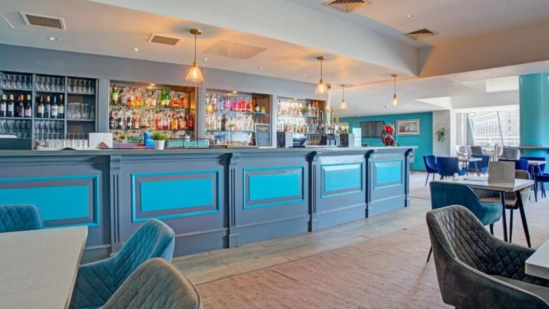 Hotel bar and dining space with long counter, seating area, and modern décor at Atlantic Tower Hotel Liverpool By Sunday.
