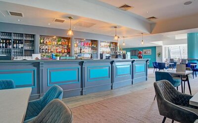 Hotel bar and dining space with long counter, seating area, and modern décor at Atlantic Tower Hotel Liverpool By Sunday.