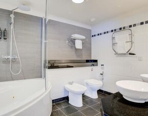 Large bathroom with bathtub, walk-in shower, bidet, and modern sink setup at Atlantic Tower Hotel Liverpool By Sunday.