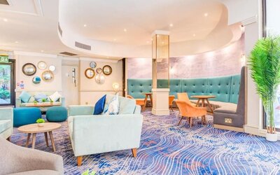 Cozy lounge area with sofas, armchairs, and decorative wall accents at Atlantic Tower Hotel Liverpool By Sunday.