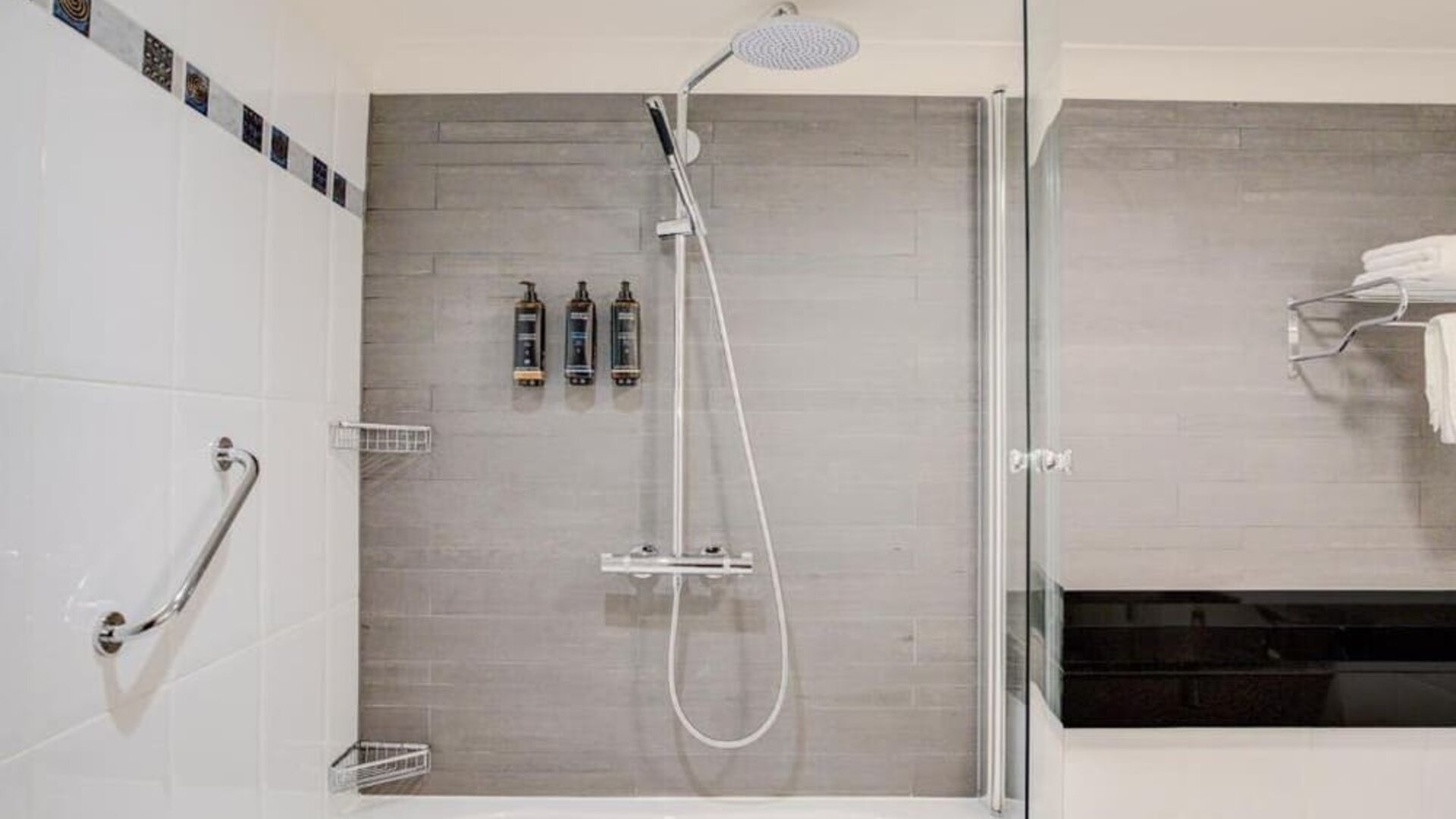 Bathroom with bathtub, rainfall shower, glass screen, and modern fixtures at Atlantic Tower Hotel Liverpool By Sunday.