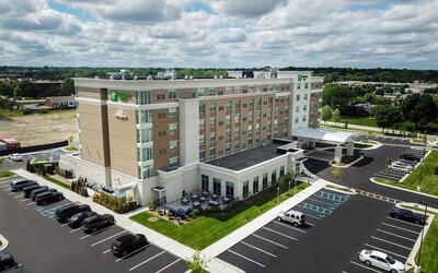 Aerial exterior view with parking lot, landscaped grounds, and hotel building at Holiday Inn & Suites Farmington Hills - Detroit NW By IHG.
