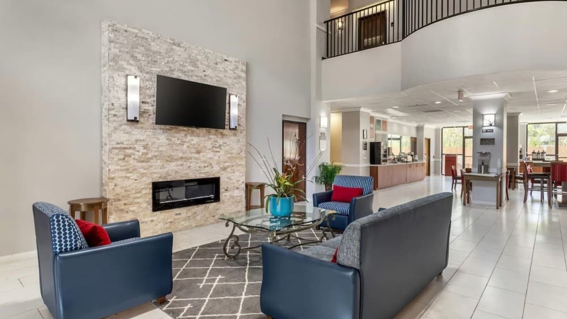 Lobby seating area with armchairs, coffee table, fireplace wall, and open layout at Comfort Suites Bush Intercontinental Airport.