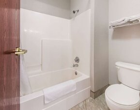 Bathroom with bathtub shower combo, toilet, towel rack, and tiled floor at Suburban Studios Mason Hwy-42.