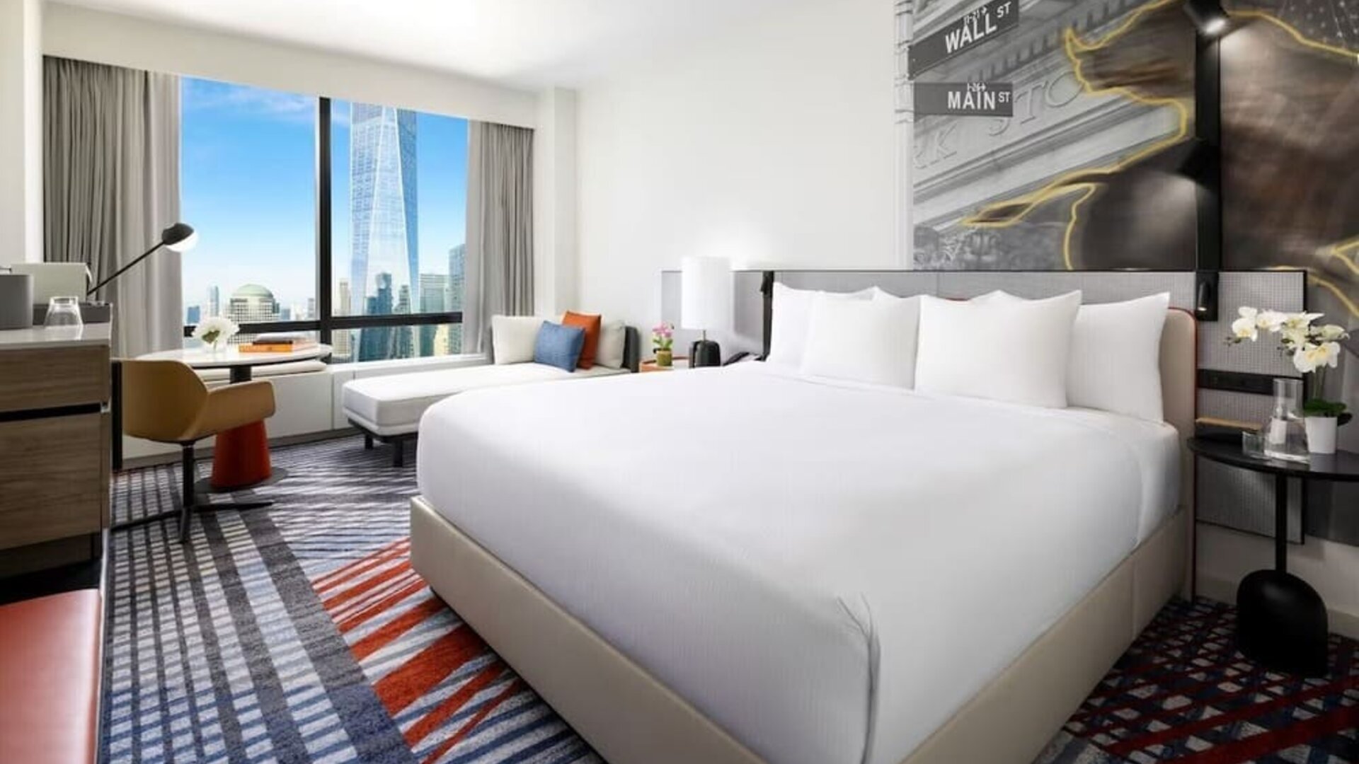 King room with large bed, city skyline view, seating area, desk, and modern décor at M Social New York Downtown.