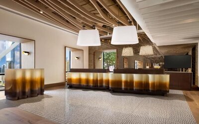 Lobby area with reception desk, modern lighting fixtures, and stylish interior design at M Social New York Downtown.