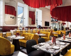 Dining area with booths, bar seating, red accents, and modern lighting design at M Social New York Downtown.