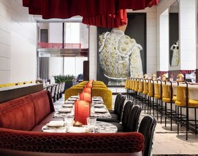 Restaurant interior with booth seating, bar area, and warm lighting at M Social New York Downtown.