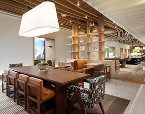 Open lounge and workspace area with communal seating, tables, and modern lighting at M Social New York Downtown.