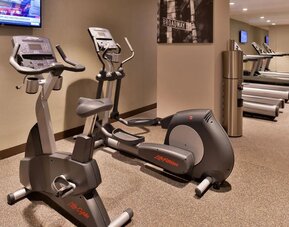 Fitness center with cardio machines including elliptical and exercise bike at Holiday Inn New York City - Times Square By IHG.