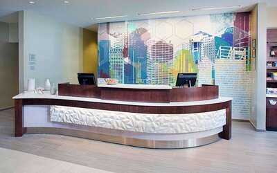 Reception desk area with modern design and colorful wall art at Springhill Suites Carle Place.