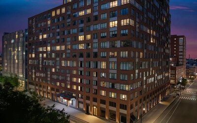 Exterior view of the hotel building at night with illuminated windows at Hilton Brooklyn New York.