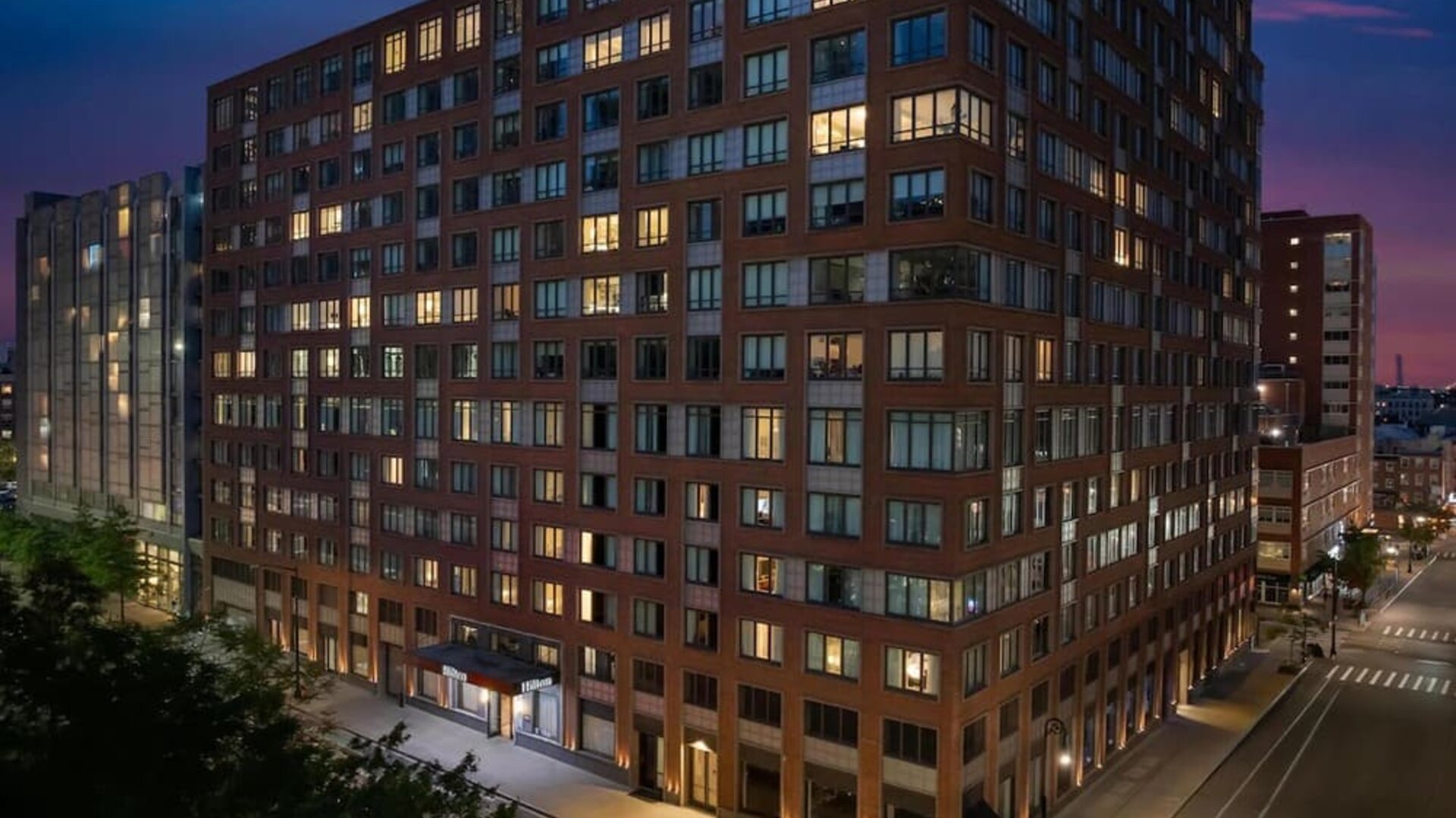 Exterior view of the hotel building at night with illuminated windows at Hilton Brooklyn New York.