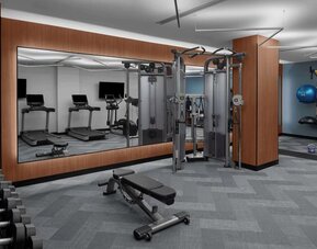 Fitness center with treadmills, weights, and strength training equipment at Hilton Brooklyn New York.