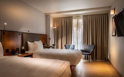 Guest room with two double beds, seating area, and large window with natural light at La Quinta Times Square South.