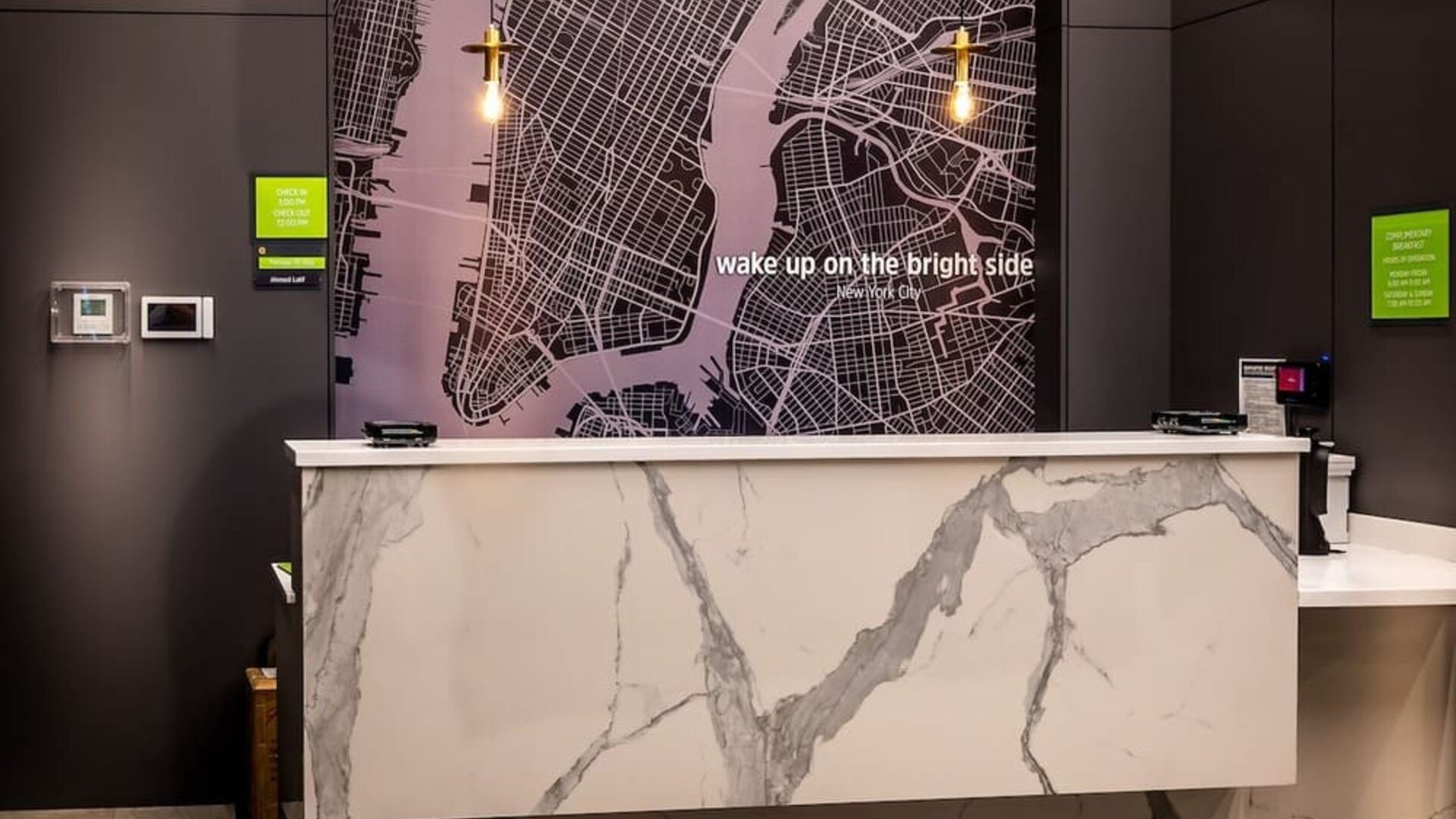 Reception area with front desk and modern décor at La Quinta Times Square South.