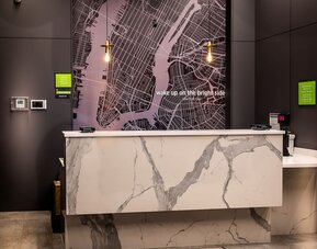 Reception area with front desk and modern décor at La Quinta Times Square South.