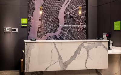 Reception area with front desk and modern décor at La Quinta Times Square South.