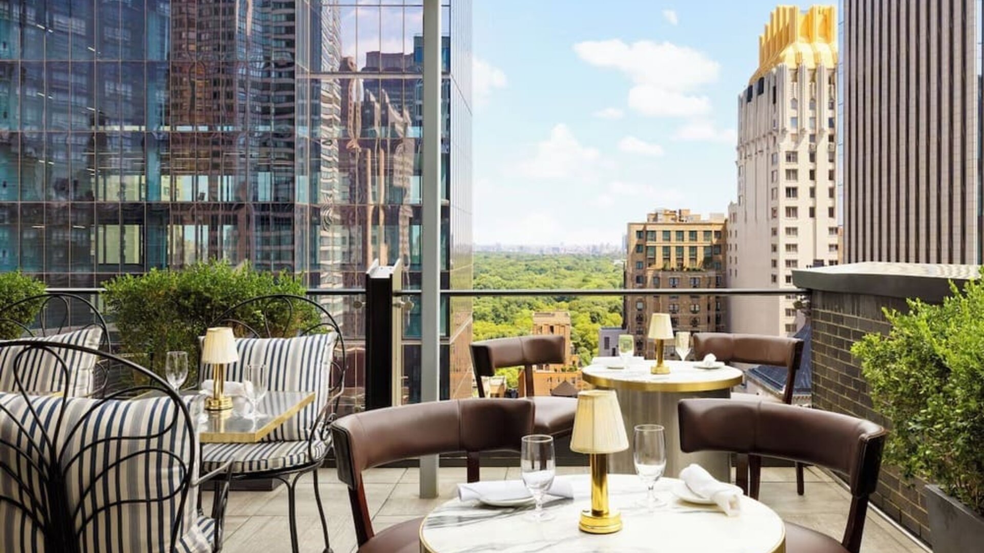 Rooftop terrace with seating, dining tables, and views of Central Park and city skyline at Le Méridien New York, Central Park.