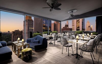 Rooftop terrace with lounge seating, dining tables, and skyline views at Le Méridien New York, Central Park.