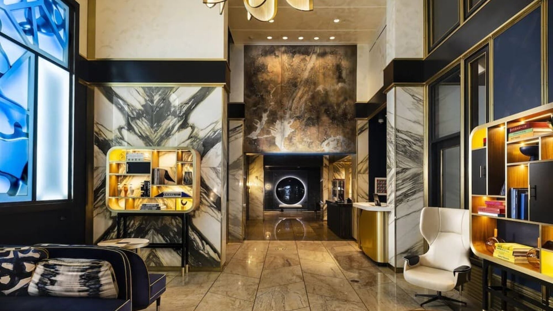 Hotel lobby with high ceilings, marble walls, seating area, and modern décor at Le Méridien New York, Central Park.