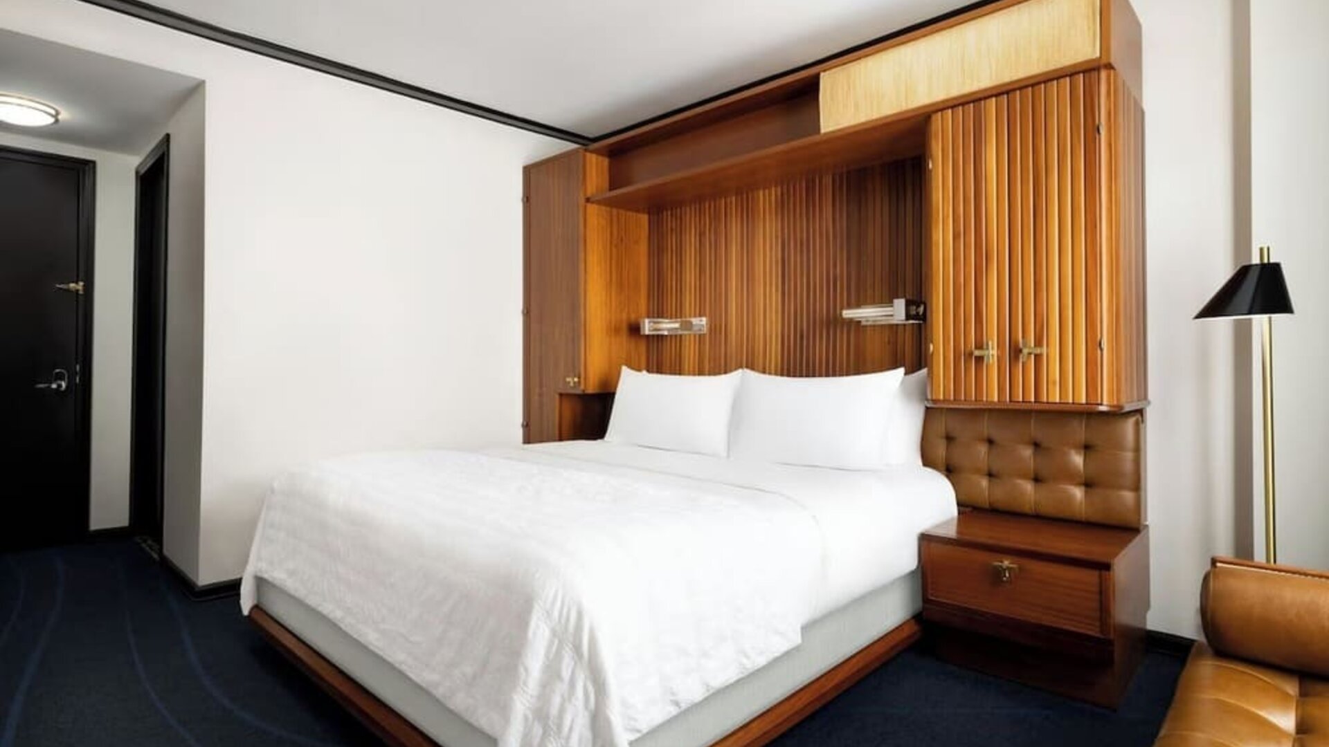 Guest room with king bed, modern décor, and workspace area at Le Méridien New York, Central Park.