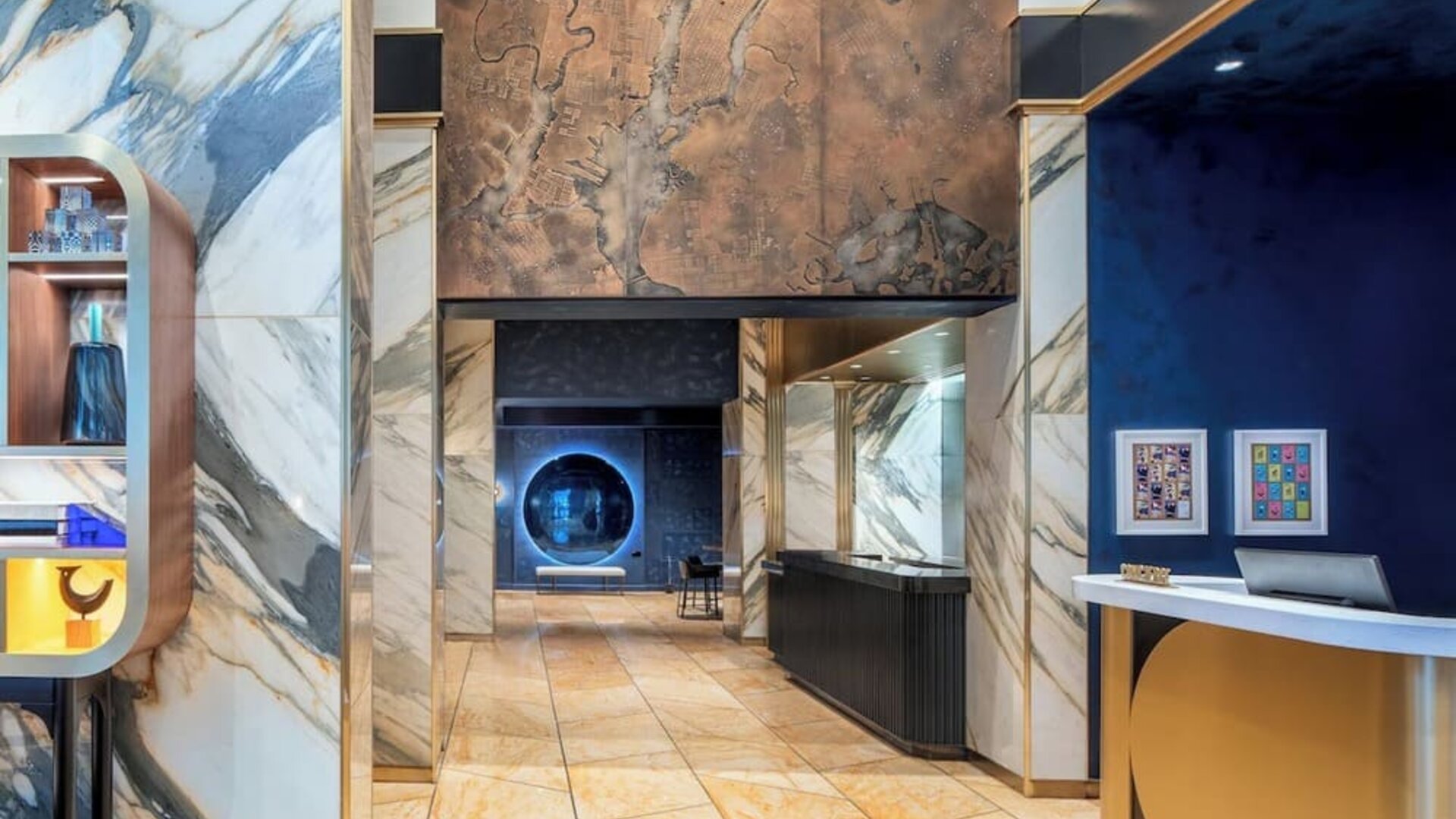 Lobby area with marble finishes, artwork, and reception desk at Le Méridien New York, Central Park.