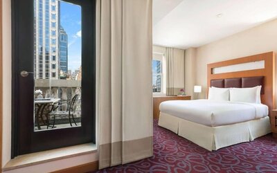 Guest room with balcony access and king bed at Hotel 57.