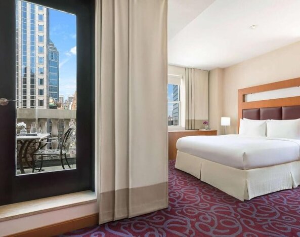 Guest room with balcony access and king bed at Hotel 57.