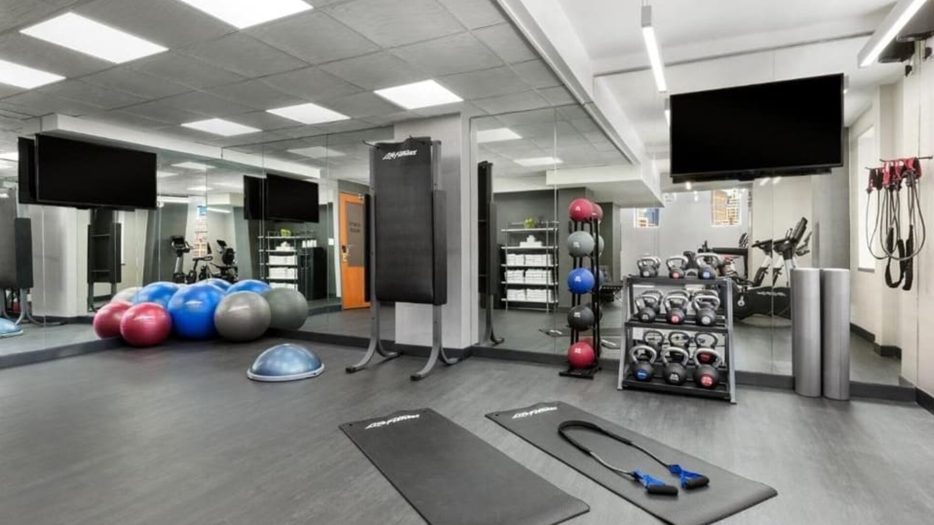 Fitness center with mats, weights, and training equipment at Hotel 57.