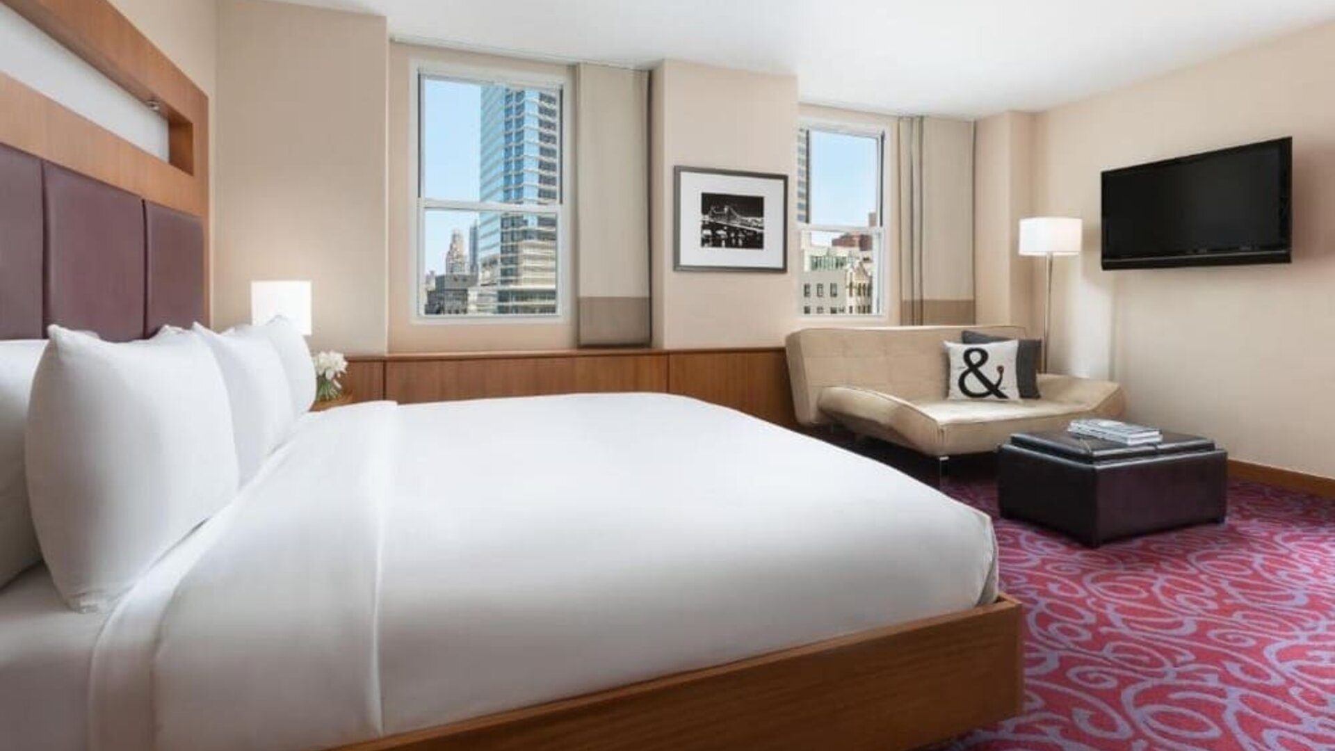 Guest room with king bed, sofa seating, and city views at Hotel 57.
