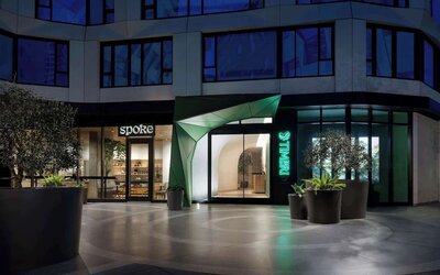 Exterior entrance of the hotel at night with illuminated signage and contemporary design at Timbri Hotel San Francisco, Curio Collection By Hilton.