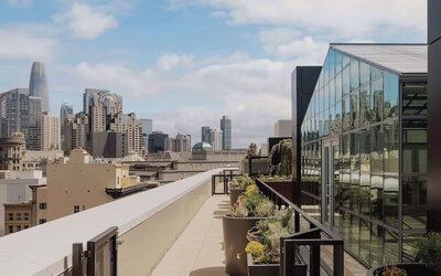 Rooftop terrace with planters, seating, and panoramic city views at Timbri Hotel San Francisco, Curio Collection By Hilton.