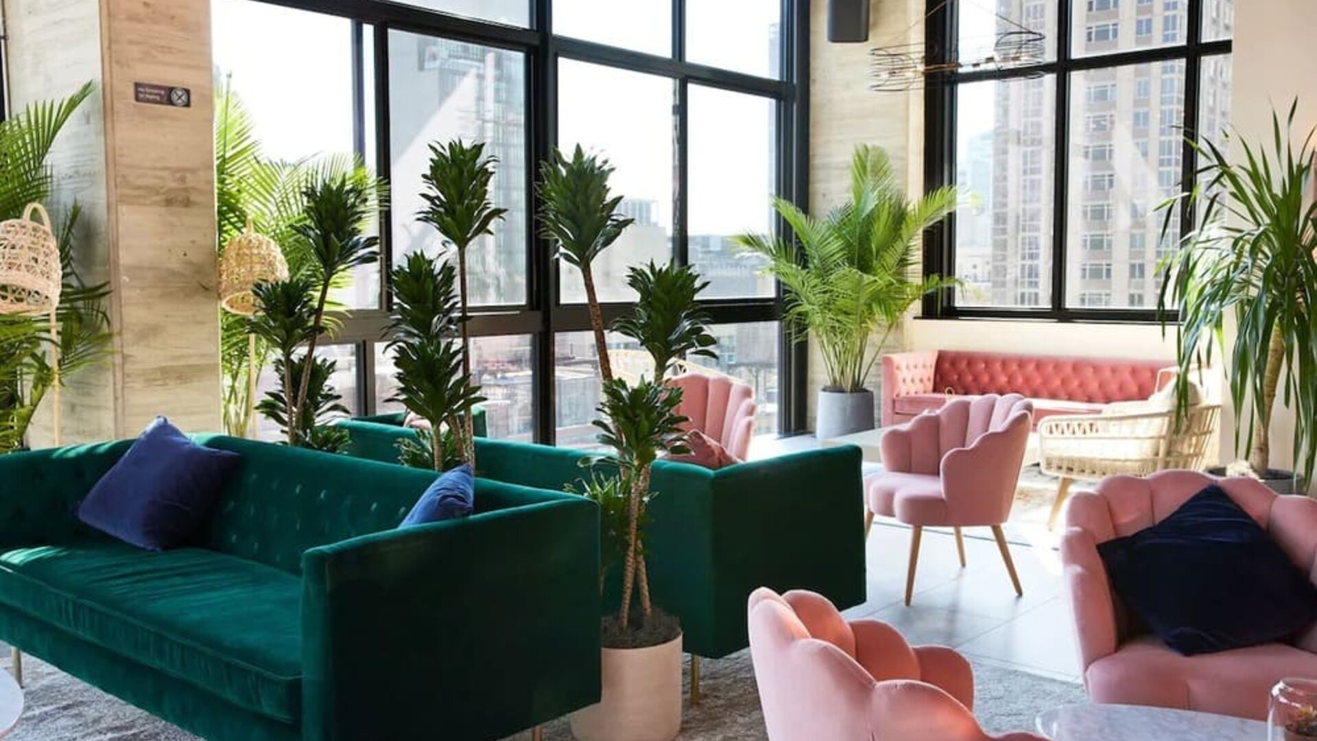 Lobby lounge with plush seating, large windows, and indoor plants at Hotel Hendricks.