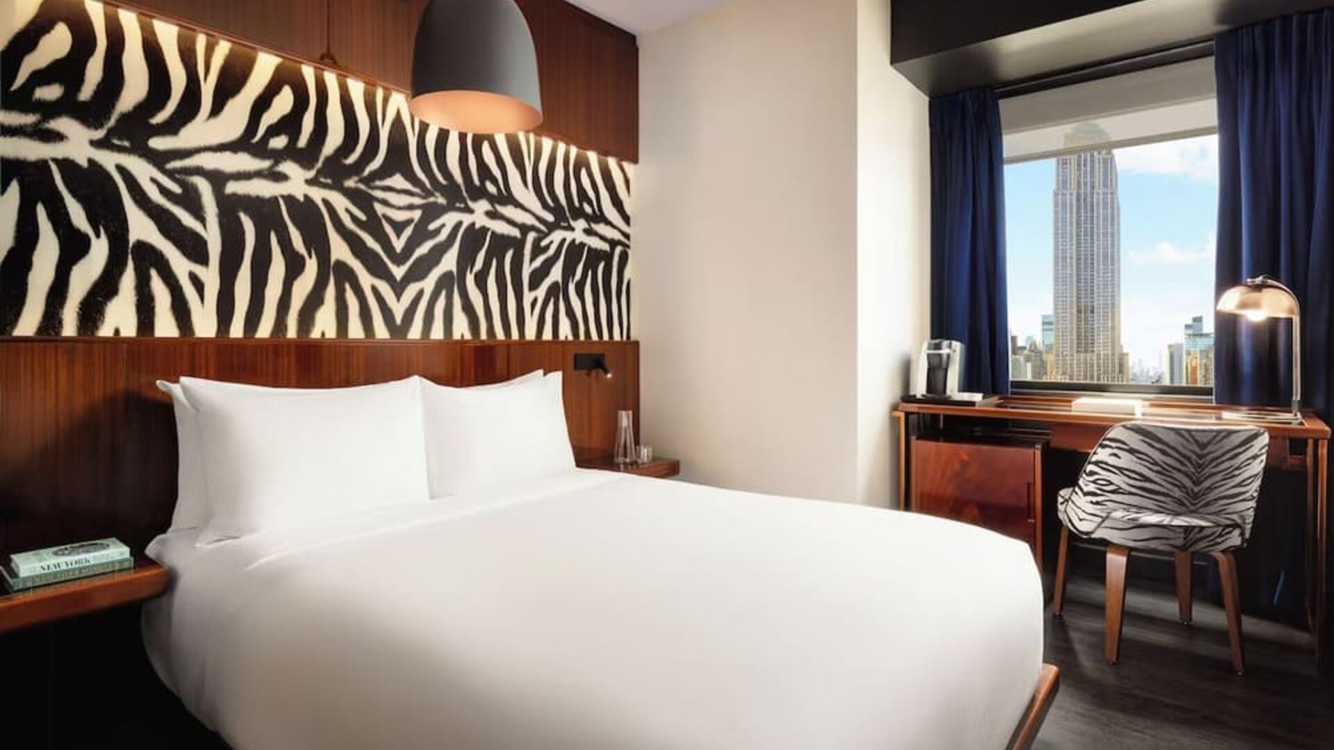 Bright room with natural light, workspace, and city skyline views at Hotel Hendricks.