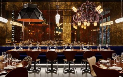 Upscale dining area with ambient lighting, chandeliers, and elegant table settings at Hotel Hendricks.
