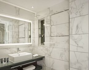 Guest bathroom with shower, mirror, and basin at 100 Queen's Gate Hotel London.