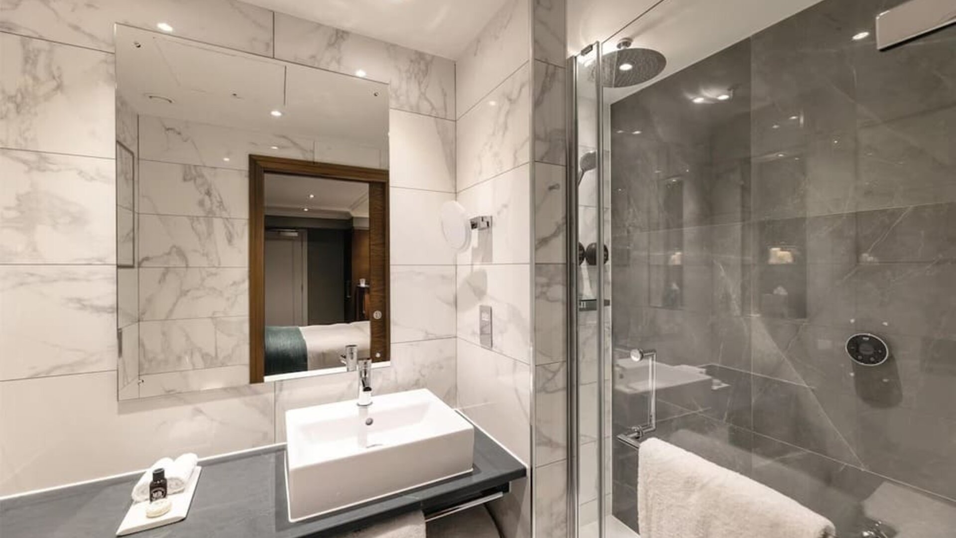 Guest bathroom with shower, mirror, and basin at 100 Queen's Gate Hotel London.