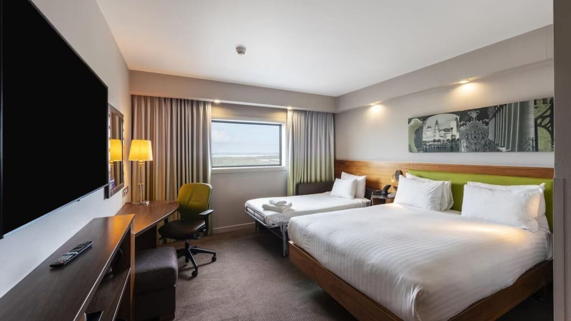 Two queen beds with TV and work desk at Hampton By Hilton Liverpool/John Lennon Airport.