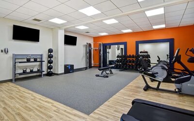 Fitness center with treadmills and weights at Hampton Inn NY-JFK.