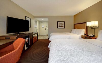 Day use room with two queen beds and work desk and TV at Hampton Inn NY-JFK.