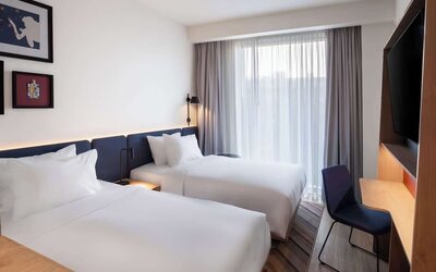 Day use room with two beds, TV, and work desk at Hampton By Hilton Tallinn.