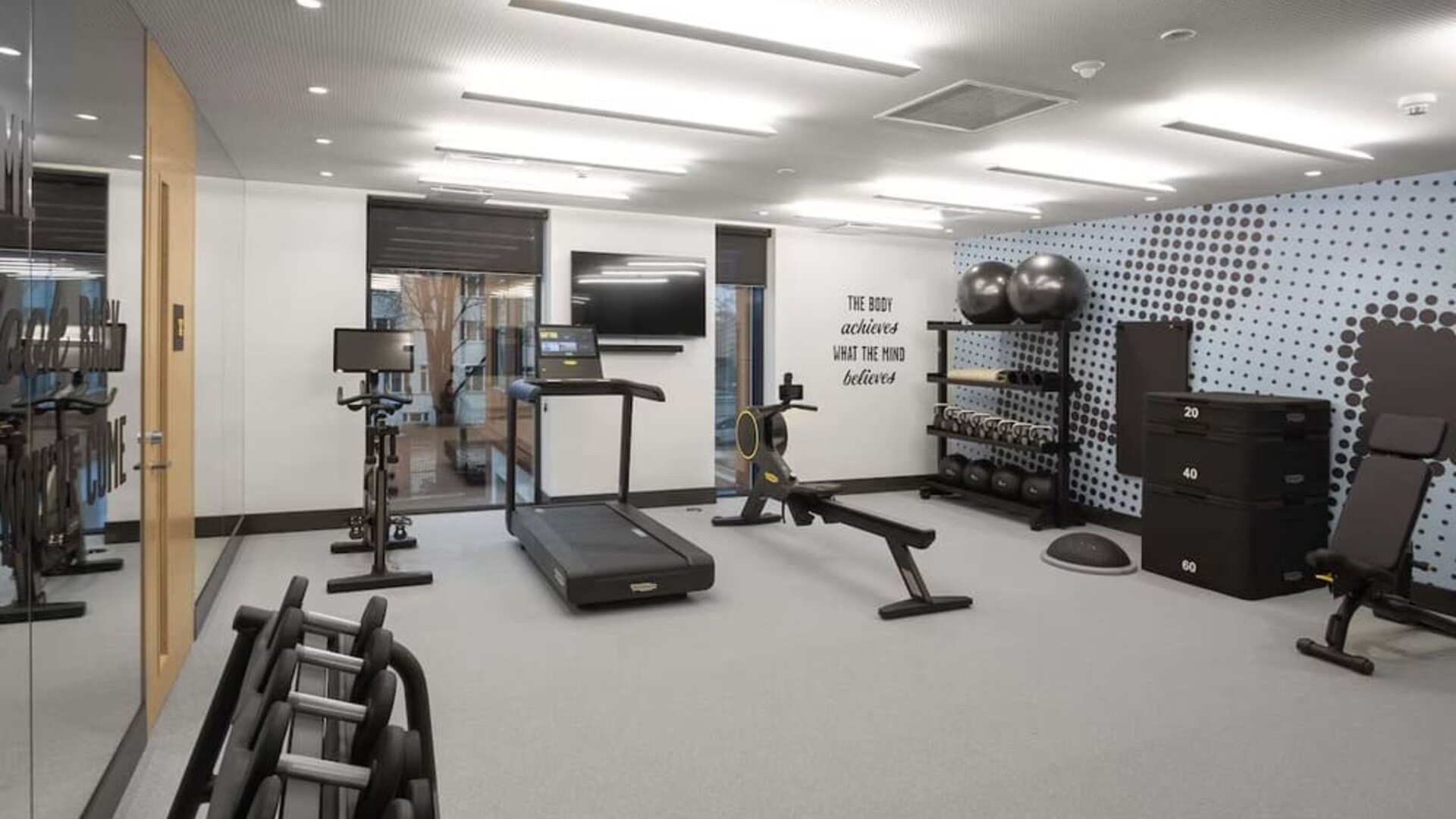 Fitness center with treadmill and weights at Hampton By Hilton Tallinn.