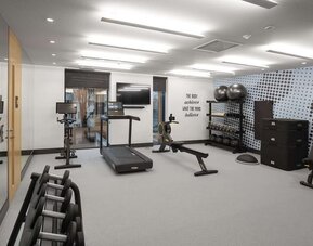 Fitness center with treadmill and weights at Hampton By Hilton Tallinn.