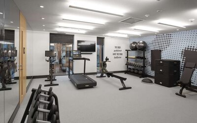 Fitness center with treadmill and weights at Hampton By Hilton Tallinn.