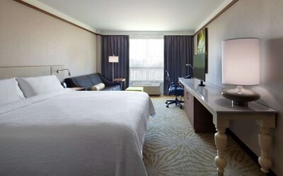 day use room with table, lamp shade, and work station at Hilton Garden Inn Montreal Airport.