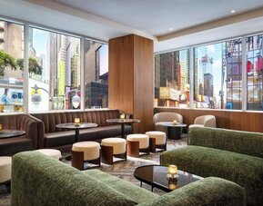 Lounge seating area with city views, sofas, and tables at Hyatt Regency Times Square.