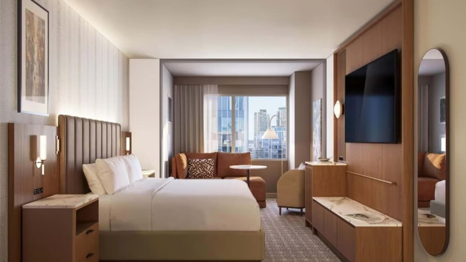 Guest room with extended seating area, sofa, and city views at Hyatt Regency Times Square.