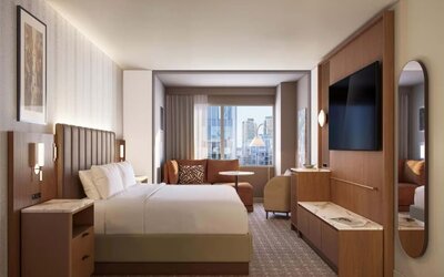 Guest room with extended seating area, sofa, and city views at Hyatt Regency Times Square.